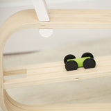 Small green toy car on a wooden shelf with a white background