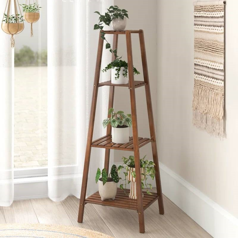 Wooden plant stand with multiple potted plants in a room setting.