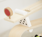 Wooden toy with a red circle and white cylindrical object on a light background