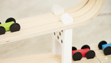 Children's toy train set on a wooden track with colorful cars.