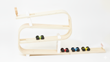 Wooden marble run with marbles on a white background