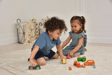 Two children playing with wooden toys on a light-colored floor.