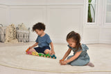 Two children playing with colorful toy cars on a light-colored rug.