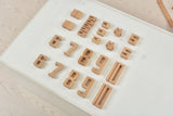 Wooden numbers on a white tray on a wooden surface