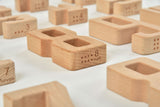 Wooden blocks with numbers and braille text on a white background