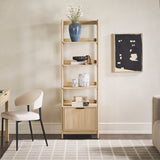 Wooden bookshelf with decorative items in a room with a chair and artwork on the wall.