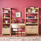 Wooden office furniture set with shelves, desk, and chair against a pink wall.