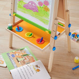 Close-up of bottom storage tray on Tiny Land wooden kids art easel keeping supplies organized