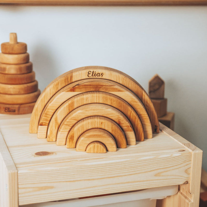 Set of wooden arch-shaped toys on a wooden surface with 'Elias' branding.