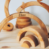 Wooden toy with arches and 'Elias' engraving on a light background