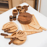 Set of wooden kitchen utensils and accessories on a white surface