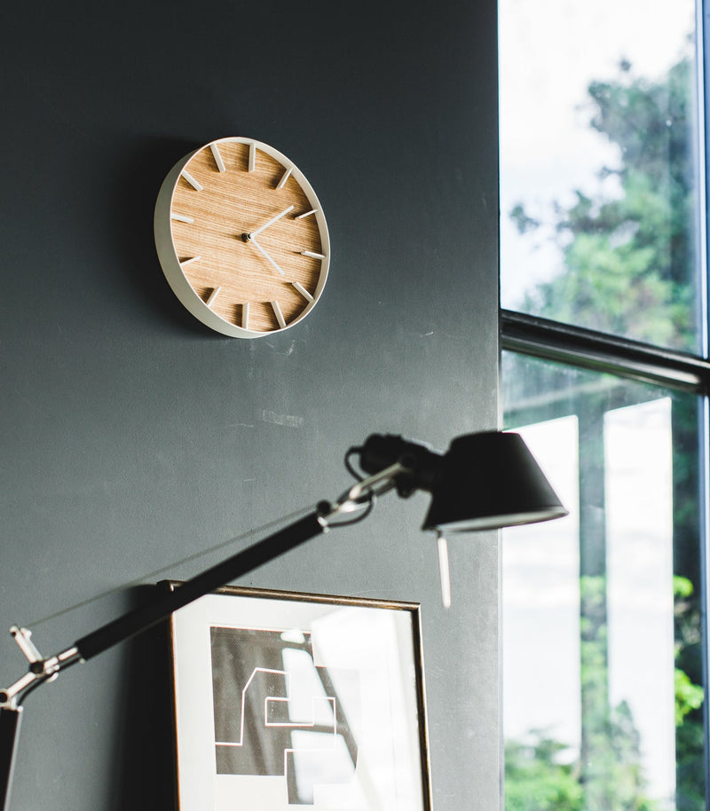 Angled side view of white Wall Clock in bedroom by Yamazaki Home.