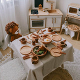 Children's play kitchen set with wooden toys and a lion figurine.