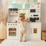 Child at sink of play kitchen