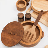 Wooden kitchen utensils including a spoon, ladle, and containers on a white background