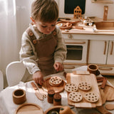 Child playing with wooden toys in a kitchen setting