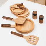Wooden kitchen utensils including spatulas, ladles, and bowls on a white surface.